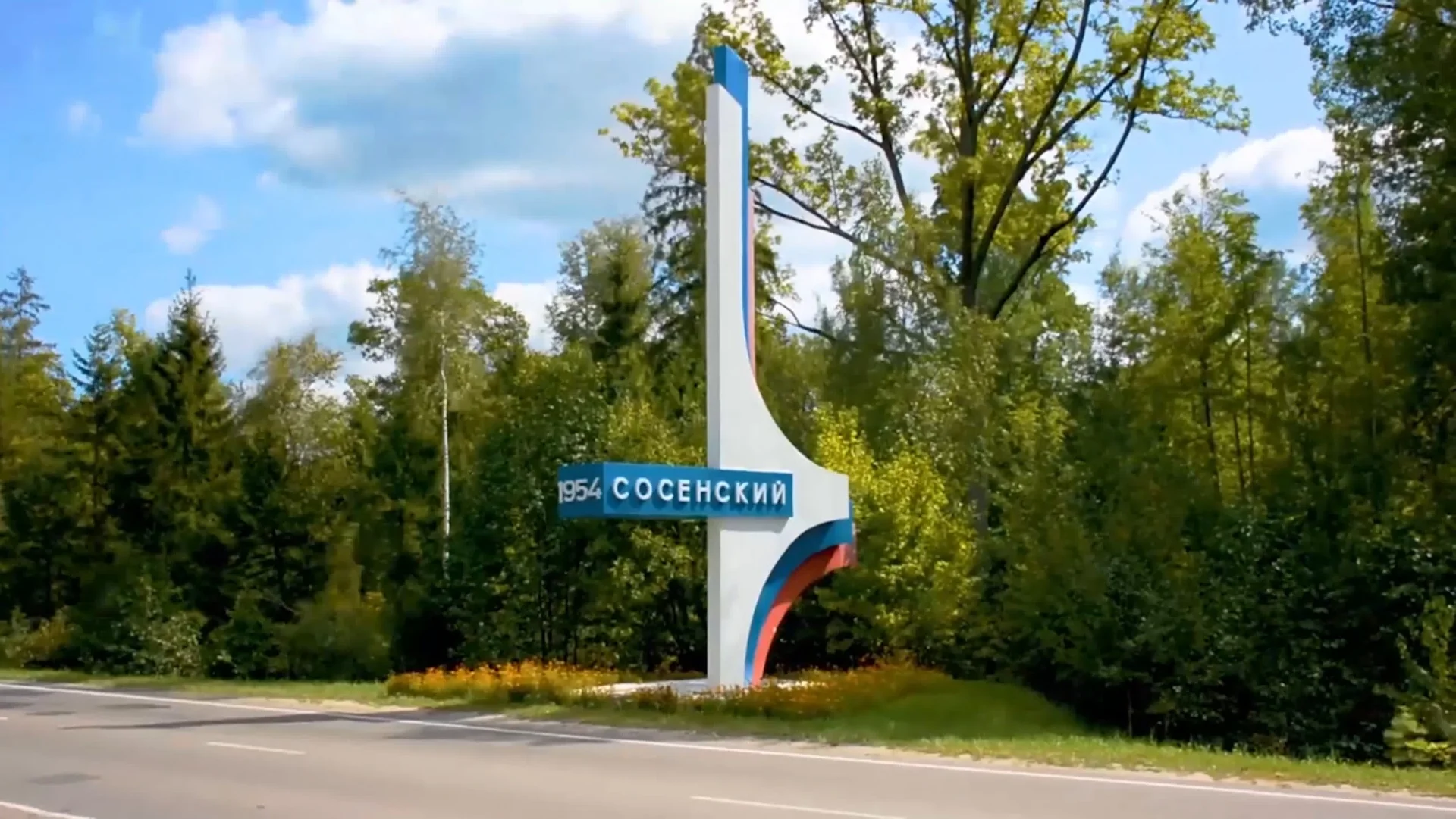 Въездная стела с названием «Сосенский» на фоне деревьев